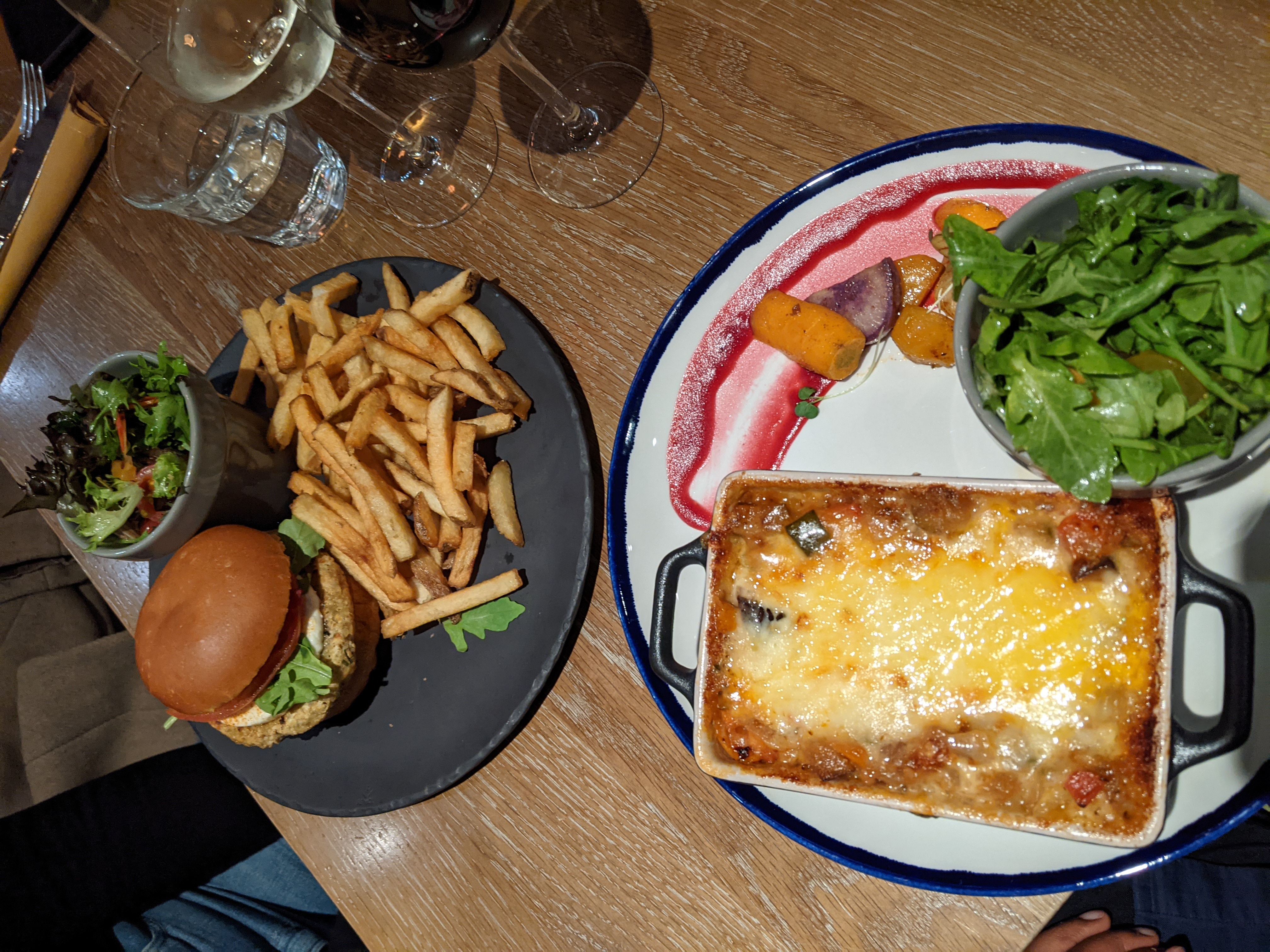 A plate of vegetarian Lasagna with salad and another vegetarian dish resembling burger and fries from a restaurant in Quebec city.