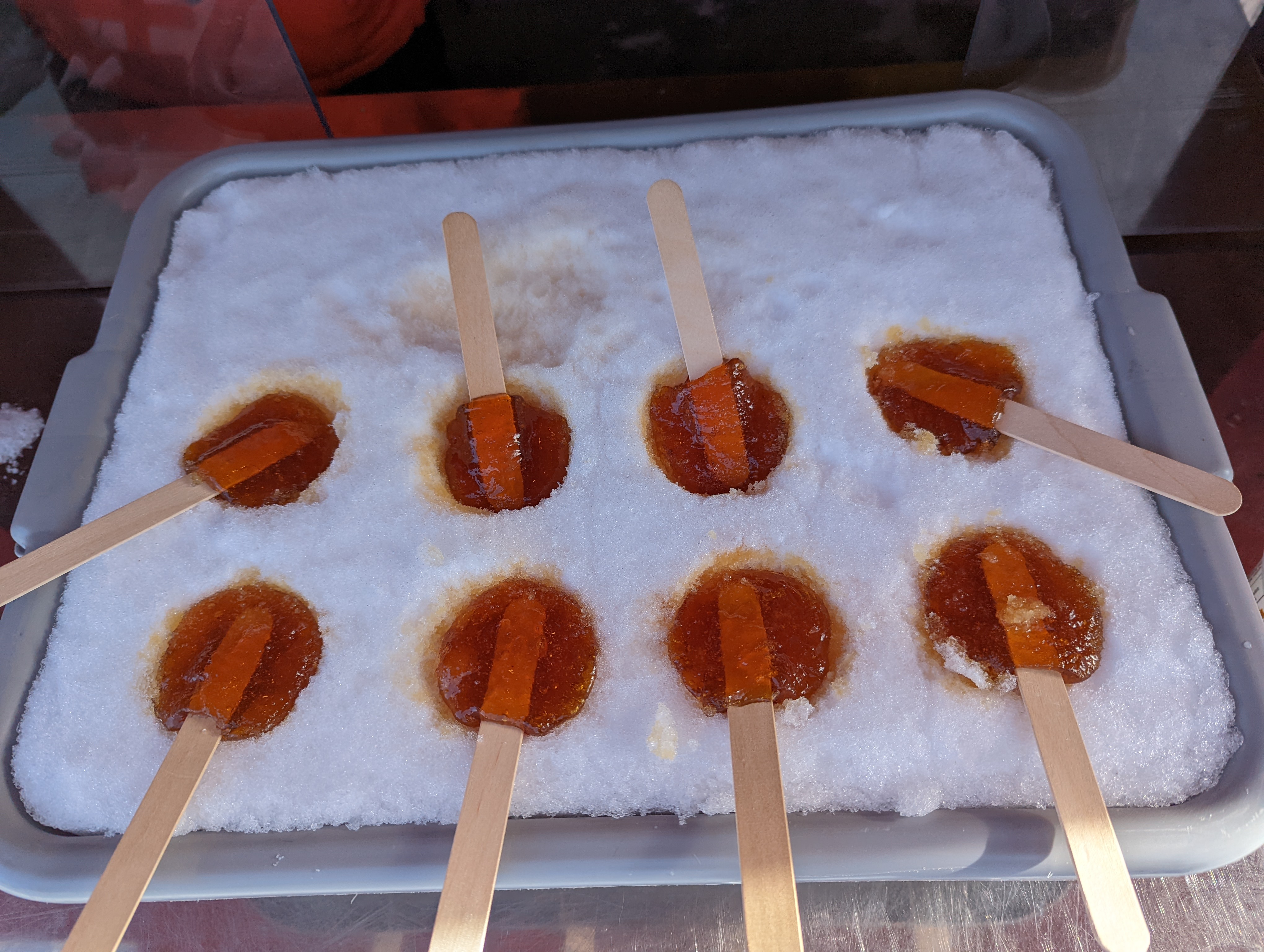 Frozen maple syrup frozen at the end of a wooden stick like a lolly pop