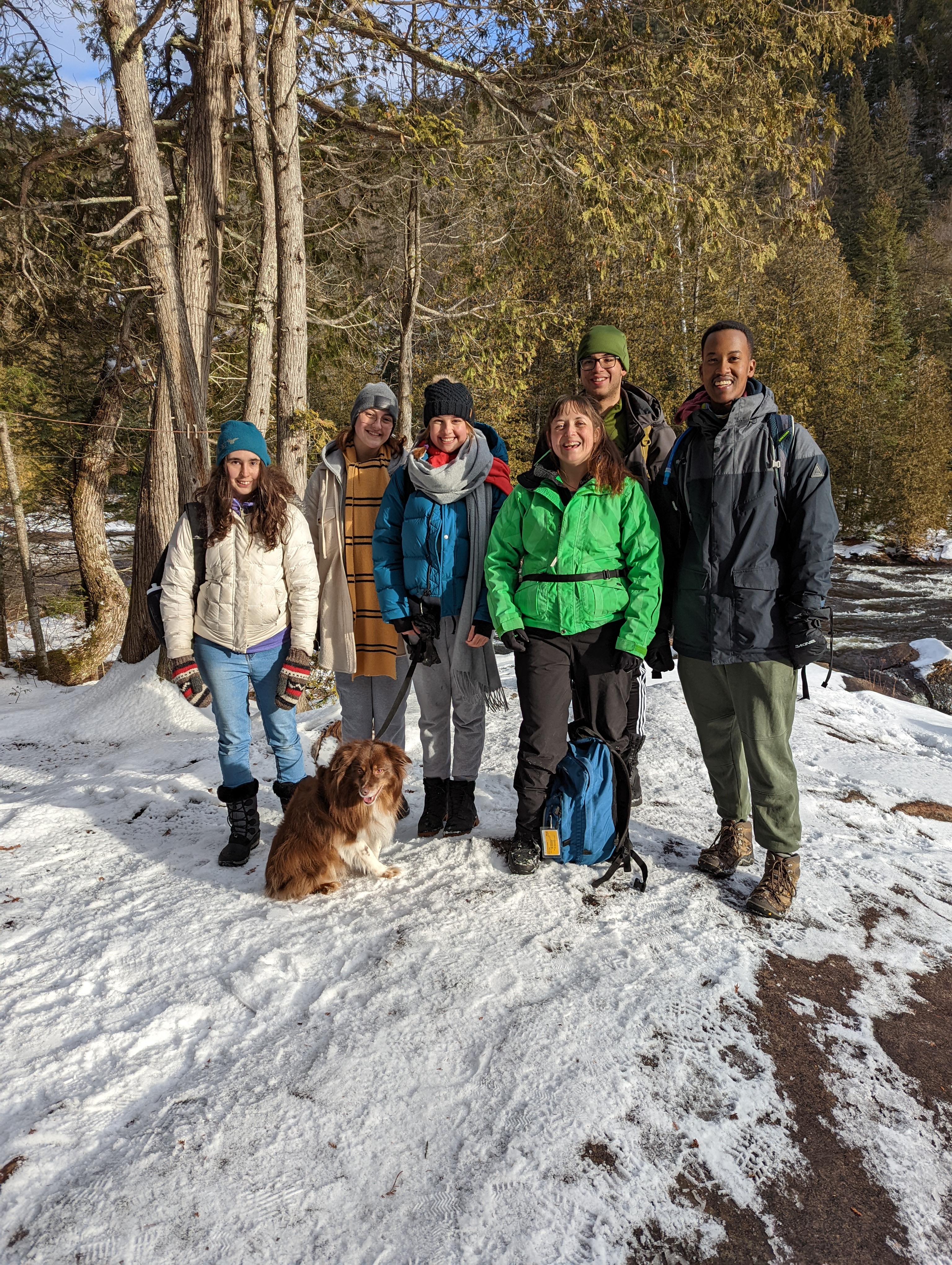 A crew of friends, students, educators and a dog posing after a long hike