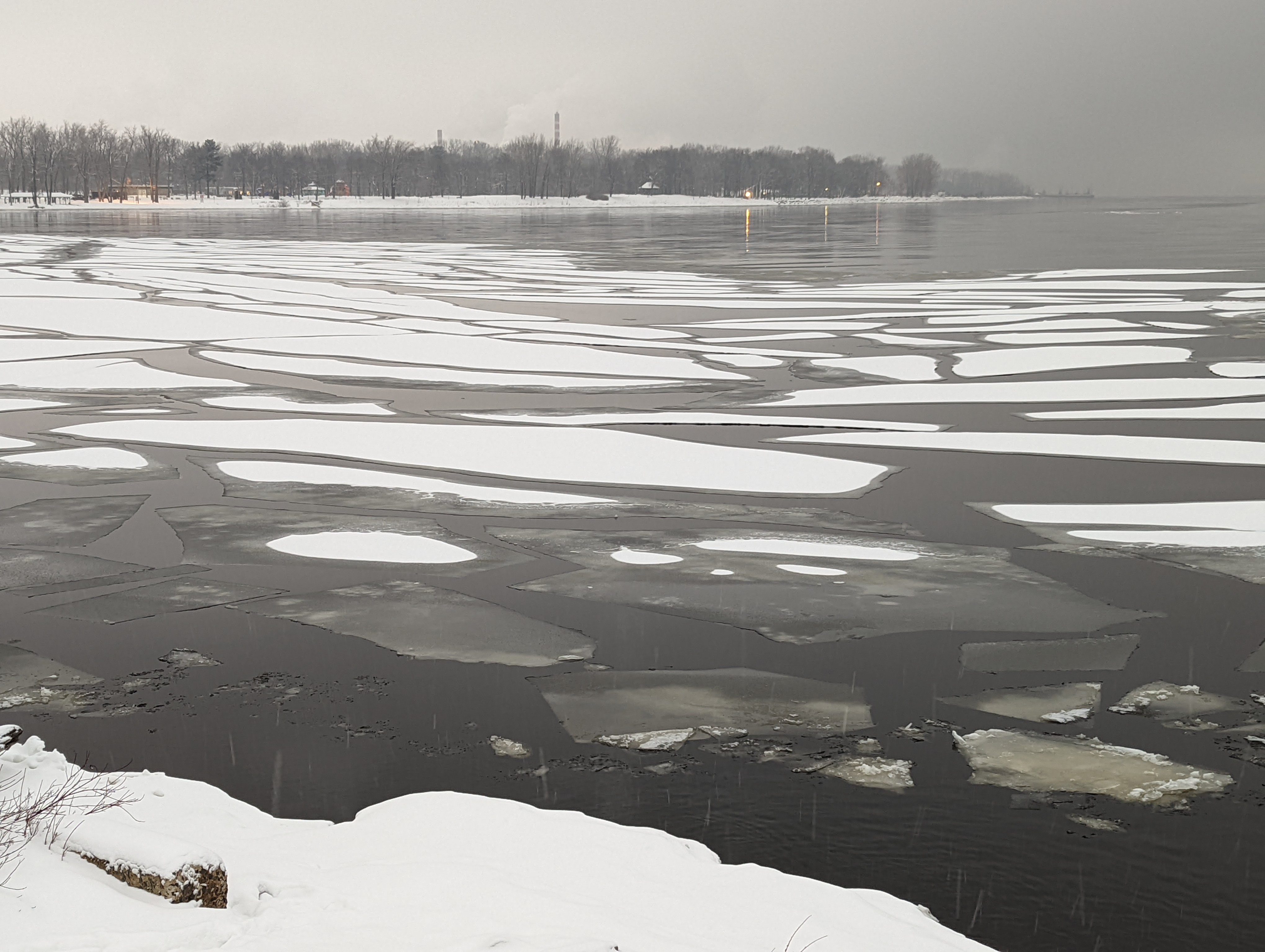 The fleuve St.Laurent covered in large pieces of snow-covered ice drifts as they float towards the shore